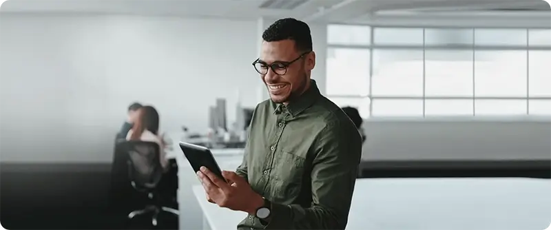 Businessman smiles while looking at smart device